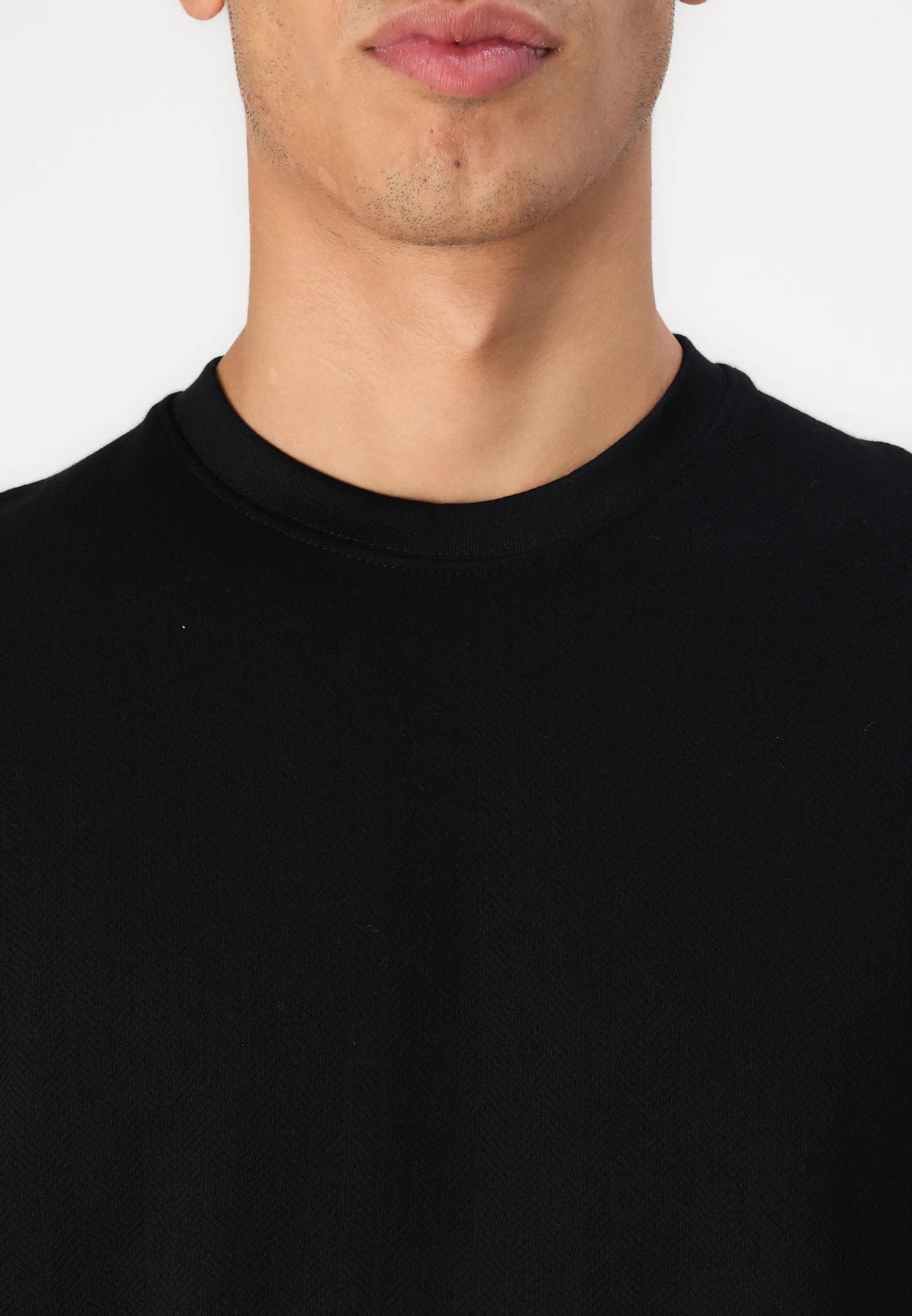 Close-up of a man's chest wearing a black t-shirt.